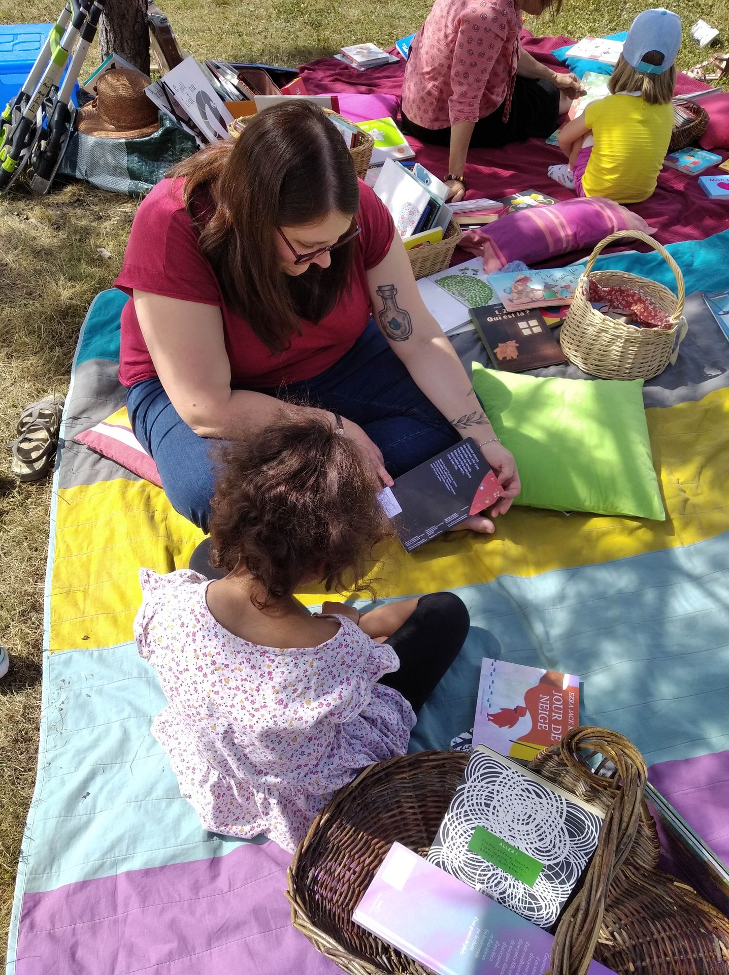 Lecture extérieure avec un enfant Lecture de livres par l'animatrice en extérieur avec une enfant