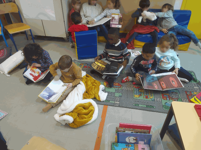 Découverte des livres Plusieurs enfants lisent seuls ou à plusieurs des livres