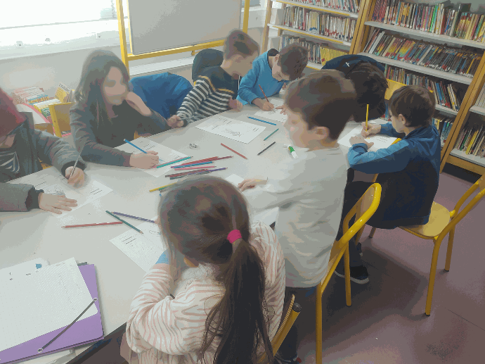 Création des personnages de jeu de rôle en élémentaire Plusieurs enfants autour d'une table écrivent et dessinent leur personnage de jeu de rôle