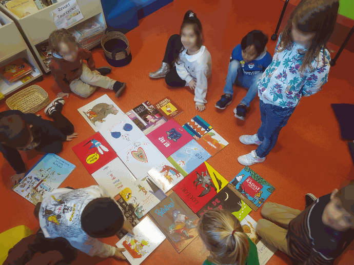 Jeux autour du livre en maternelle Plusieurs enfants autour d'un domino de livres